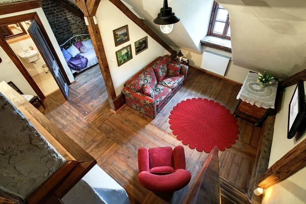 Duplex apartment at Apartamenty Kamienica Muzyków in Lublin, featuring exposed wooden beams, rustic décor, and a cozy living area.