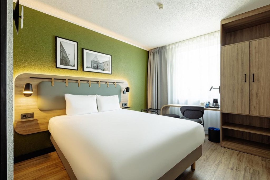 Modern double room with a green accent wall at Campanile PRIME in Lublin.