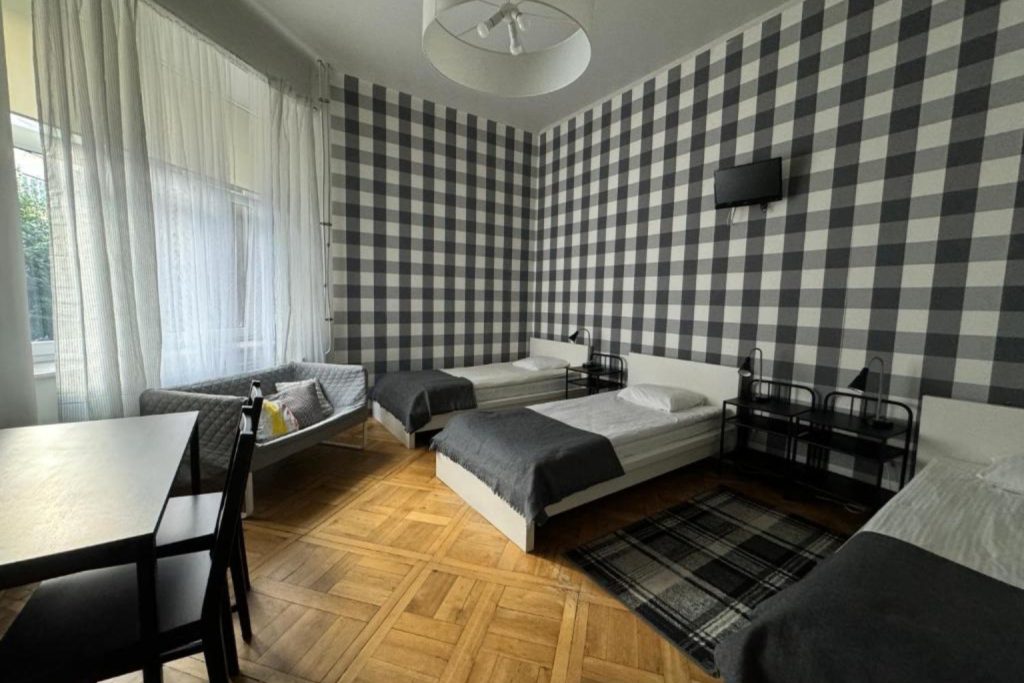 Triple room with single beds and checkered walls at Cent Hostel in Lublin Centrum