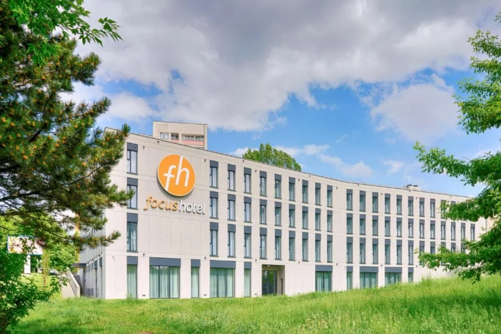 Nowoczesny budynek hotelowy z jasną elewacją otoczony zielenią w Focus Hotel Premium Lublin, Lublin, Poland