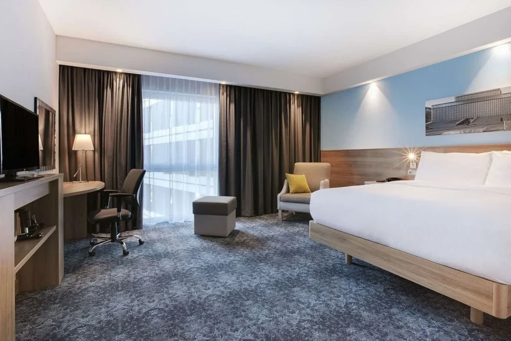 Modern guest room with a workspace at Hampton by Hilton Lublin in Lublin, Poland.