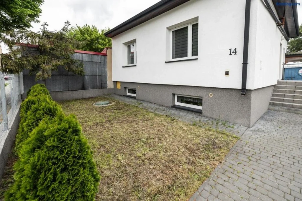 Widok na budynek z niewielkim ogrodem i zielenią przed obiektem – Hostel Śliska, Lublin.