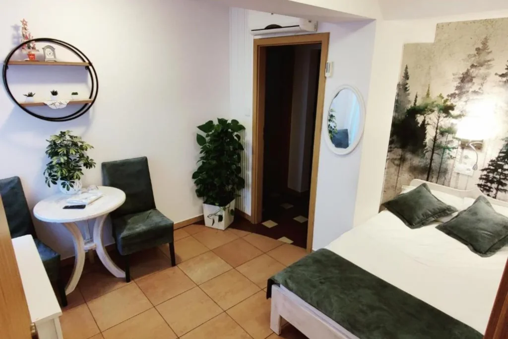 Cozy double room with a seating area, decorative wall mural, and modern furnishings at Hotel Finezja in Lublin, Poland.