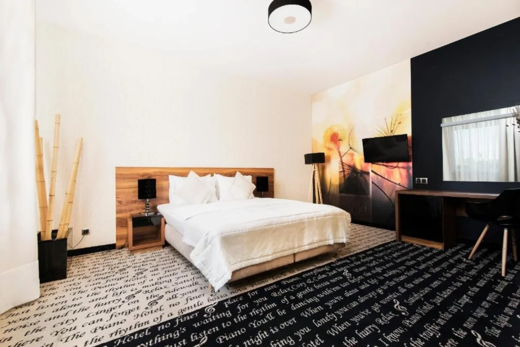 Nowoczesny pokój z dużym łóżkiem, dekoracyjną ścianą i miejscem do pracy w Hotel i Restauracja Piano Lublin