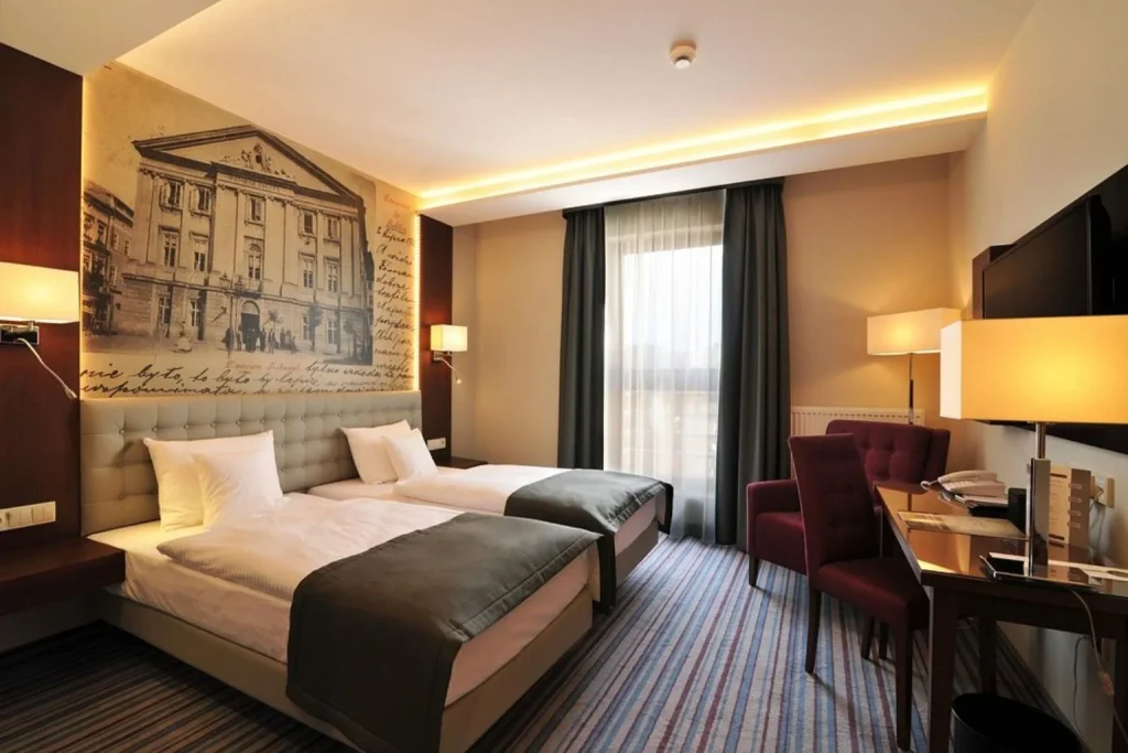 Standard twin guest room with two single beds and a work desk at Hotel Wieniawski in Lublin, Poland.
