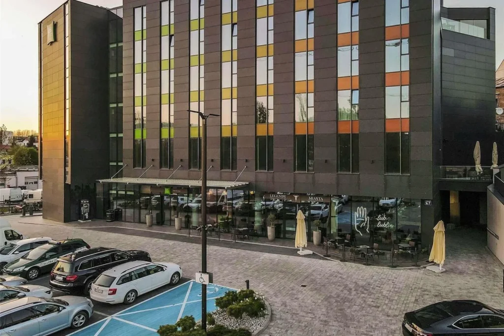 Modern exterior of Ibis Styles Lublin Old Town in Lublin with outdoor seating and parking area
