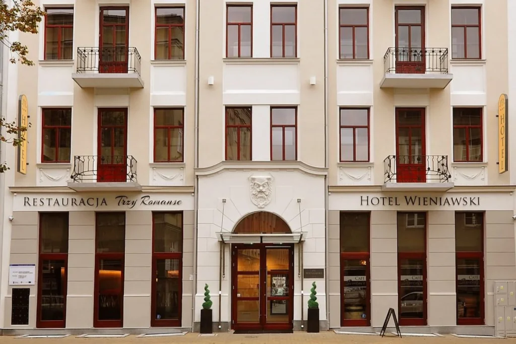 Cream-colored facade with decorative architectural details, balconies, and a central entrance at Wieniawski Hotel Lublin